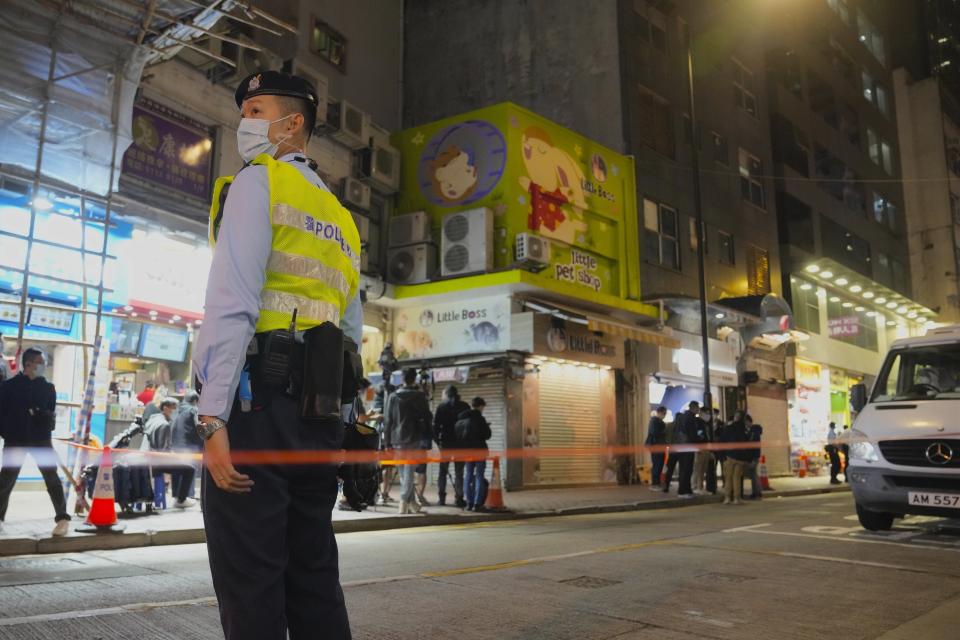 FILE - A police officer stands guard outside a pet store that was closed after some pet hamsters were, authorities said, tested positive for the coronavirus, in Hong Kong on Jan. 18, 2022. The city is culling small animals including hamsters and chinchillas and halting their import and sales after several hamsters in the pet shop tested positive for the coronavirus.(AP Photo/Kin Cheung, File)