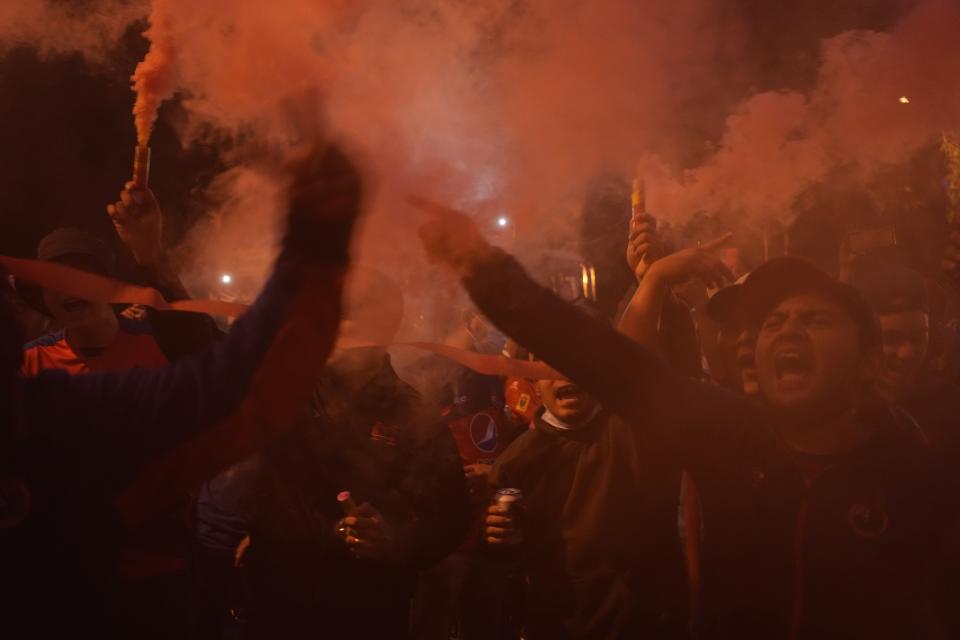 Fans of Guatemala's Municipal cheer for their team after clashing with fans of Honduras' Olimpia outside Doroteo Guamuch stadium, before a CONCACAF League soccer match in Guatemala City, Thursday, Aug. 18, 2022. (AP Photo/Moises Castillo)