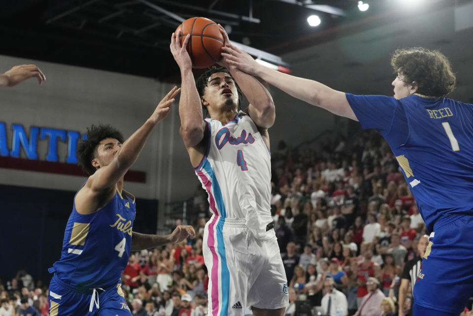 Tulsa guard PJ Haggerty (4) and forward Matt Reed (1) defend Florida Atlantic guard Bryan Greenlee (4) during the first half of an NCAA college basketball game, Saturday, Feb. 3, 2024, in Boca Raton, Fla. (AP Photo/Marta Lavandier)