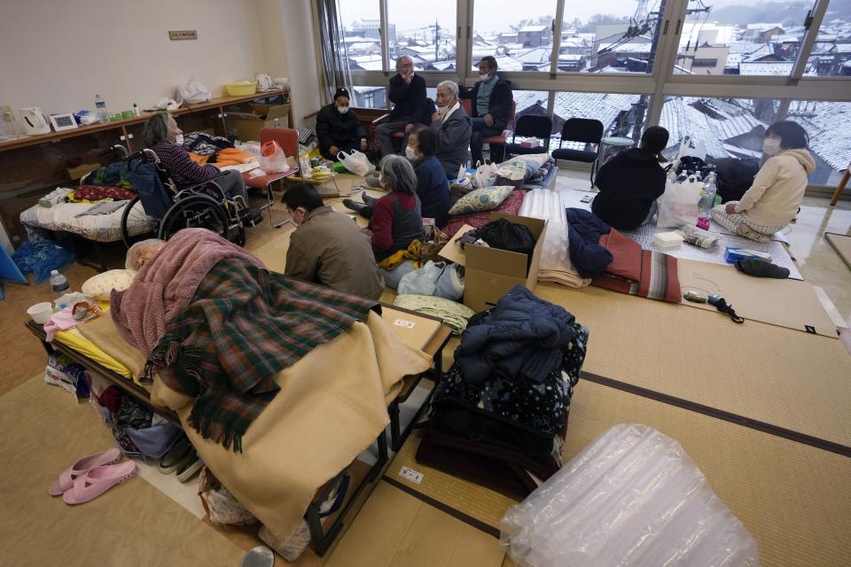 Evacuees from a deadly earthquake take refuge at an evacuation center in Wajima in the Noto peninsula facing the Sea of Japan, northwest of Tokyo, Sunday, Jan. 7, 2024. Monday's temblor decimated houses, twisted and scarred roads and scattered boats like toys in the waters, and prompted tsunami warnings. (AP Photo/Hiro Komae)