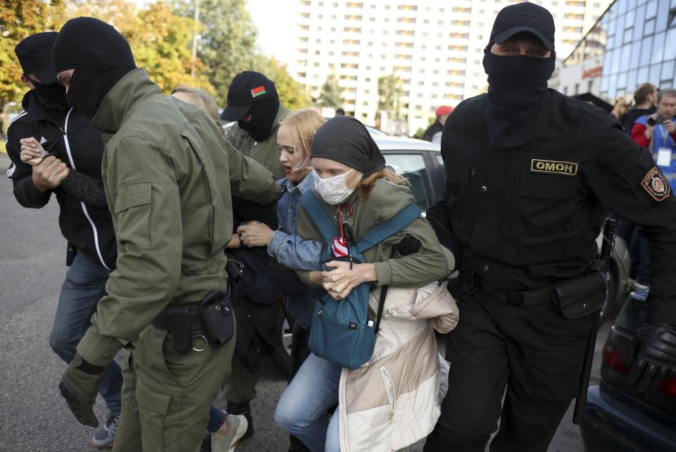 Police officers detain two women during an opposition rally to protest the official presidential election results in Minsk, Belarus, Saturday, Sept. 19, 2020. Daily protests calling for the authoritarian president's resignation are now in their second month and opposition determination appears strong despite the detention of protest leaders. (AP Photo/TUT.by)