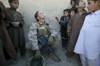 MUSA QALA, AFGHANISTAN - NOVEMBER 21: (SPAIN OUT, FRANCE OUT, AFP OUT) Sargent Sheena Adams, 25, US Marine with the FET (Female Engagement Team) 1st Battalion 8th Marines, Regimental Combat team II blows bubbles with Afghan boys surrounding her while on patrol on November 21, 2010 in Musa Qala, Afghanistan. There are 48 women presently working along the volatile front lines of the war in Afghanistan deployed as the second Female Engagement team participating in a more active role, gaining access where men can't. The women, many who volunteer for the 6.5 month deployment take a 10 week course at Camp Pendleton in California where they are trained for any possible situation, including learning Afghan customs and basic Pashtun language. (Photo by Paula Bronstein/Getty Images)