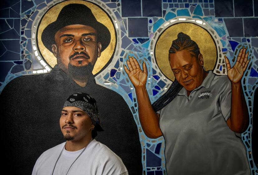 LOS ANGELES, CA-NOVEMBER 11, 2023, 2023: Fernando Torres, 20, a graduate of FREE L.A.High, a charter school associated with the Youth Justice Coalition, is photographed at Chuco's Justice Center in South Los Angeles, where the school is located. Directly behind Torres is a mural of Jesse "Chuco" Becerra, who the justice center was named after. (Mel Melcon / Los Angeles Times)