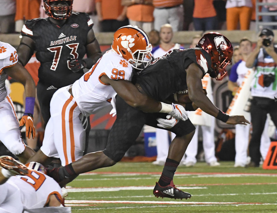 Louisville’s Lamar Jackson (8) is wrapped up by Clemson’s Clelin Ferrell (99) during the first half of an NCAA college football game, Saturday, Sept. 16, 2017, in Louisville, Ky. (AP Photo/Timothy D. Easley)