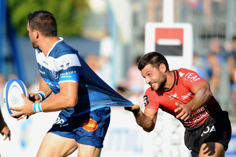 Castres' Remy Grosso (L) is tackled by Toulon's scrum-half Jonathan Pelissie during their French Top 14 rugby union match, at Pierre Antoine Stadium in Castres, on August 30, 2015