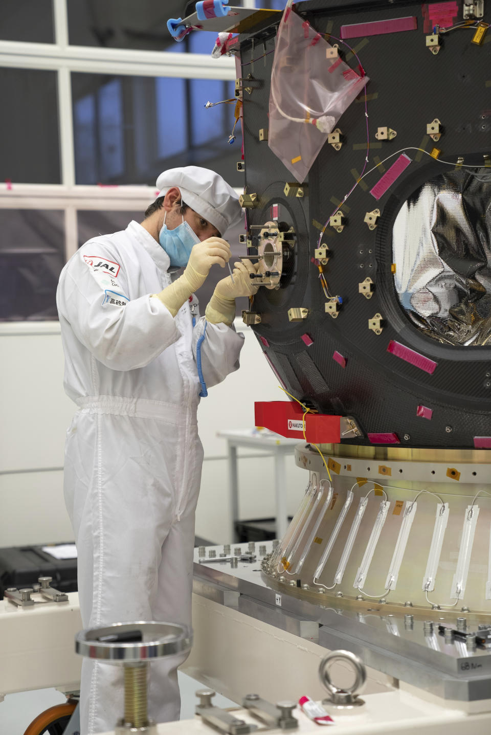 In this photo provided by ispace in April 2023, a technician works on the Hakuto spacecraft in Japan. On Tuesday, April 25, 2023, flight controllers plan to direct the craft to descend from orbit and land on the moon's surface. (ispace via AP)