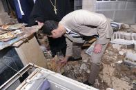 In this photo released on the official Facebook page of the Syrian Presidency, Syrian President Bashar Assad checks a broken religious icon during his visit to the Christian village of Maaloula, near Damascus, Syria, Sunday April, 20, 2014. Assad toured a historic Christian village his forces recently captured from rebels, state media said, as the country's Greek Orthodox Patriarch vowed that Christians in the war-ravaged country "will not submit and yield" to extremists. The rebels, including fighters from the al-Qaida-affiliated Nusra Front, took Maaloula several times late last year. (AP Photo/Syrian Presidency via Facebook)