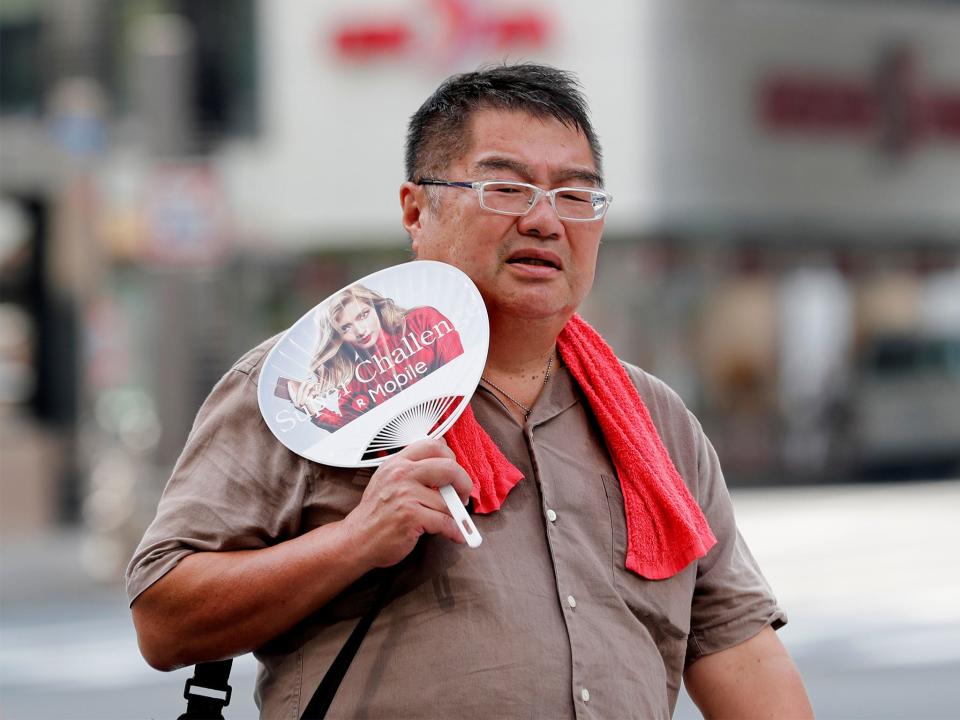 A man uses a fan as he walks on a street in Tokyo: Reuters