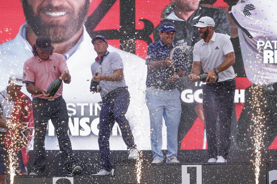 The "4 Aces" team celebrates with champagne after winning the team competition during a ceremony after the final round of the Bedminster Invitational LIV Golf tournament in Bedminster, N.J., Sunday, July 31, 2022. From left to right, Pat Perez, Talor Gooch, Patrick Reed and Dustin Johnson. (AP Photo/Seth Wenig)