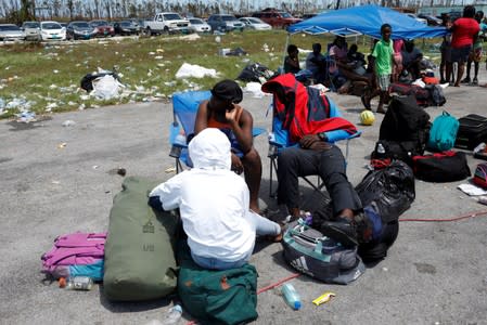 People wait in line to get in a airplane during an evacuation operation after Hurricane Dorian hit the Abaco Islands in Treasure Cay