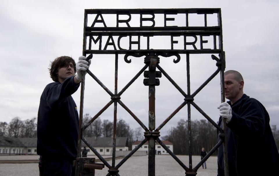 Employees of a transport company carry the gate with the writing "Arbeit macht frei" (Work Sets you Free) at the memorial of the former Nazi concentration camp in Dachau, Germany, Wednesday, Feb. 22, 2017. The gate was stolen in 2014 and reappeared in November 2016 near the city of Bergen in Norway. (Sven Hoppe/dpa via AP)