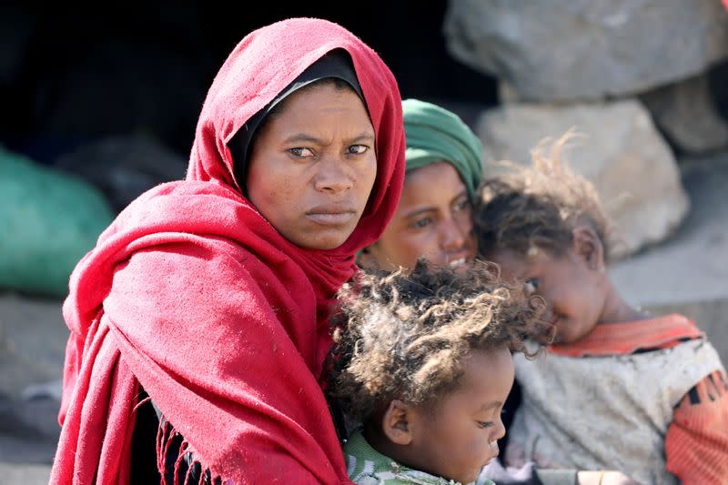 FILE PHOTO: Woman looks as she sits with her children at a camp for internally displaced people on the outskirts of Sanaa
