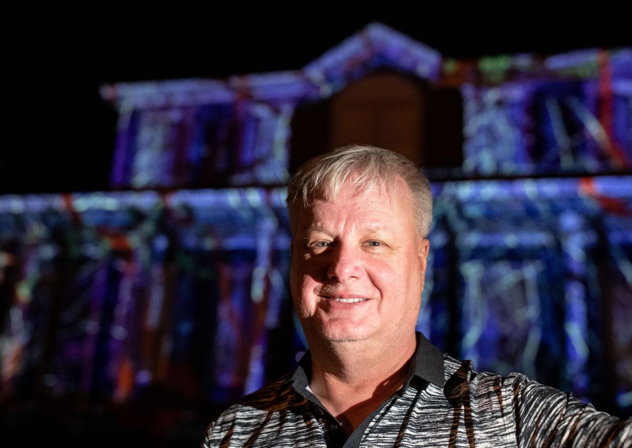 Carl Fuqua poses for a portrait in front of a spooky scene projected on his Southwood home Friday, Oct. 21, 2022.