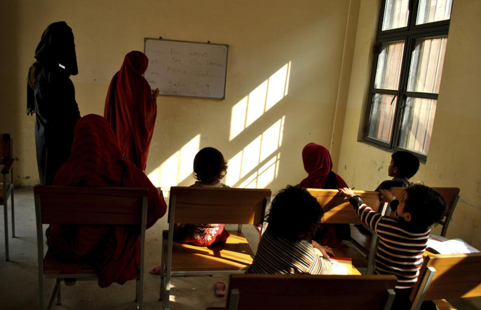 FILE - In this Nov. 8, 2018 file photo, a Pakistani woman prisoner teaches fellow inmates and their children at a central jail in Mardan, Pakistan. Kanizan Bibi, charged with murdering her employer's wife and five children, remains a prisoner on death row for the last 29 years. She’s one of more than 600 mentally ill prisoners in Pakistan’s overcrowded prisons. (AP Photo/Saba Rehman,file)