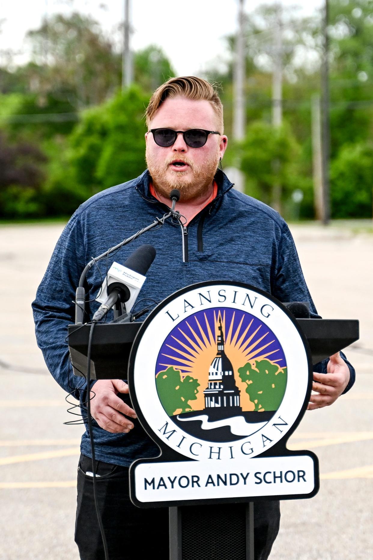 City council member Ryan Kost speaks during a press conference at the proposed site of city hall at a parking lot on Grand Avenue across from CATA's downtown transportation center on Thursday, May 9, 2024, in Lansing.