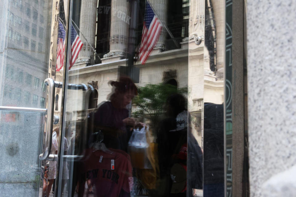 People walk by the New York Stock Exchange (NYSE) on August 2, 2023, the day after Fitch downgraded the U.S. credit rating. (Photo by Spencer Platt/Getty Images)