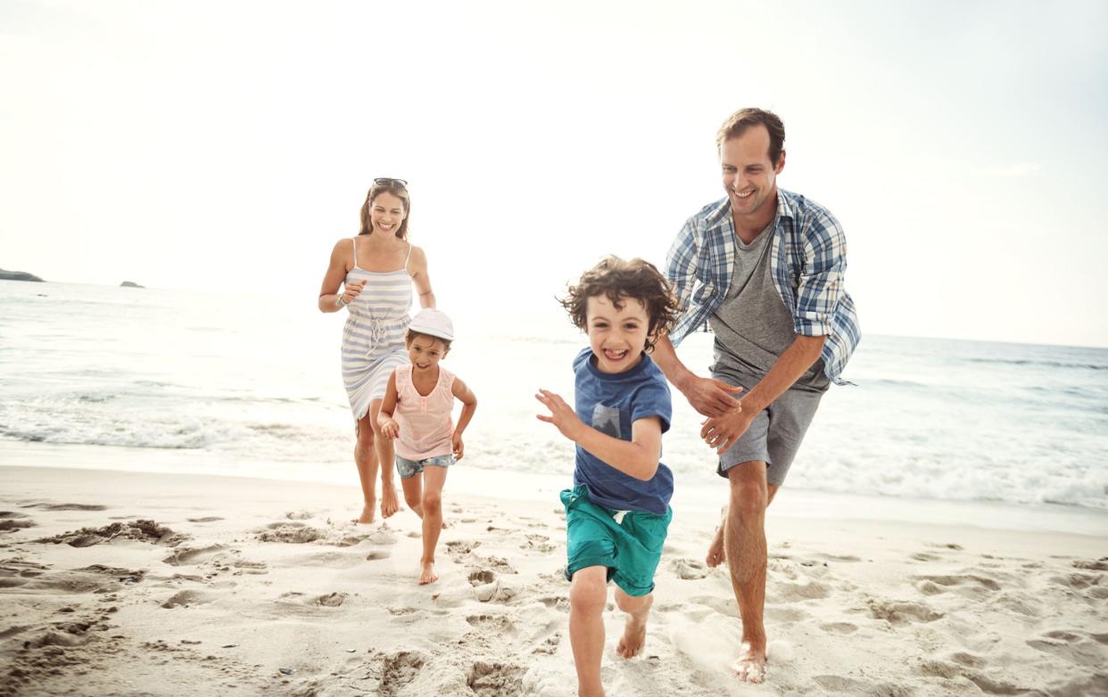 happy young family running on the beach