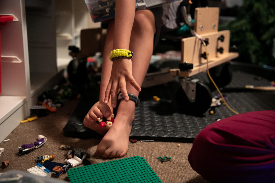 Braden uses his toes to reach for a LEGO on a break inbetween physical therapy treatments. | Ilana Panich-Linsman for TIME
