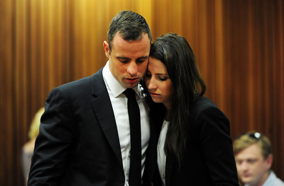 Oscar Pistorius hugs his sister Aimee, right, in court in Pretoria, South Africa, Wednesday, March 19, 2014. Pistorius is on trial for the murder of his girlfriend Reeva Steenkamp on Valentine's Day in 2013. (AP Photo/Leon Sadiki, Pool)