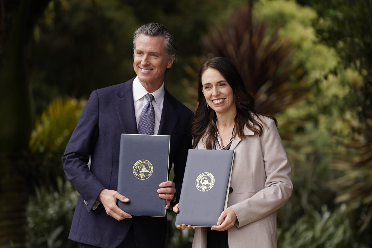 California Gov. Gavin Newsom and New Zealand Prime Minister Jacinda Ardern pose with agreements they signed at the San Francisco Botanical Garden in San Francisco, Friday, May 27, 2022. Gov. Newsom met with Ardern in Golden Gate Park "to establish a new international partnership tackling climate change." (AP Photo/Eric Risberg)