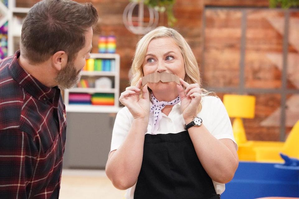 Nick Offerman watches as his "Making It" co-host Amy Poehler jokes around on set.