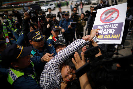 An activist who opposes releasing balloons containing leaflets denouncing North Korean leader Kim Jong Un, is dragged out of an anti-North Korea civic group, near the demilitarized zone in Paju, South Korea, May 5, 2018. REUTERS/Kim Hong-Ji