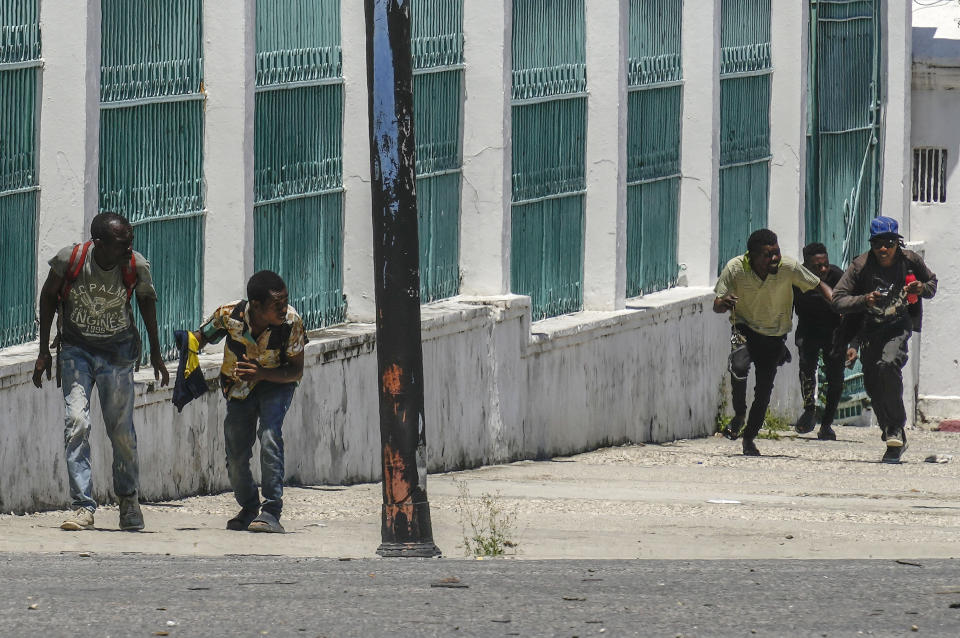 People run for cover as shots ring near the National Palace, in Port-au-Prince, Haiti, Tuesday, April 30, 2024. (AP Photo/Ramon Espinosa)