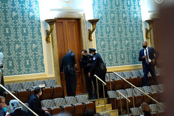 WASHINGTON, DC - JANUARY 06: U.S. Capitol Police draw their guns as protesters attempt to enter the House Chamber during a joint session of Congress on January 06, 2021 in Washington, DC. Congress held a joint session today to ratify President-elect Joe Biden's 306-232 Electoral College win over President Donald Trump. A group of Republican senators said they would reject the Electoral College votes of several states unless Congress appointed a commission to audit the election results. (Photo by Drew Angerer/Getty Images)