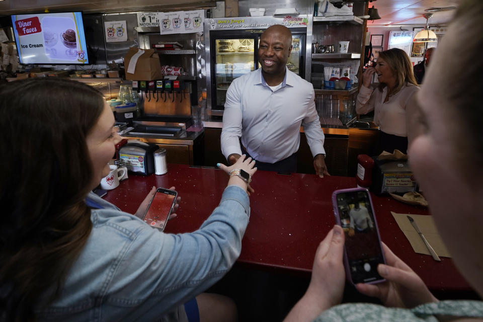 Sen. Tim Scott, R-S.C., shakes hands with diners at the breakfast counter during a visit to the Red Arrow Diner, Thursday, April 13, 2023, in Manchester, N.H. Scott on Wednesday launched an exploratory committee for a 2024 GOP presidential bid, a step that comes just shy of making his campaign official. (AP Photo/Charles Krupa)