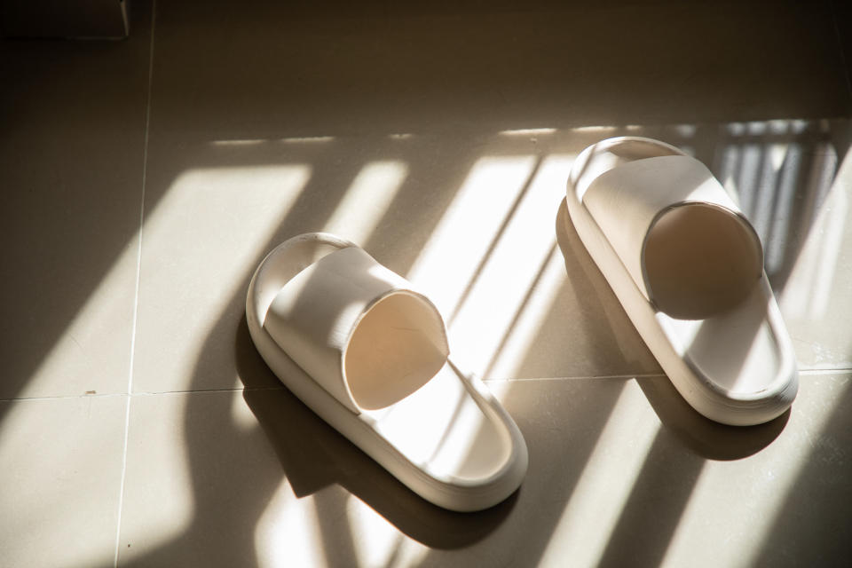 A pair of rubber slippers on a tile floor