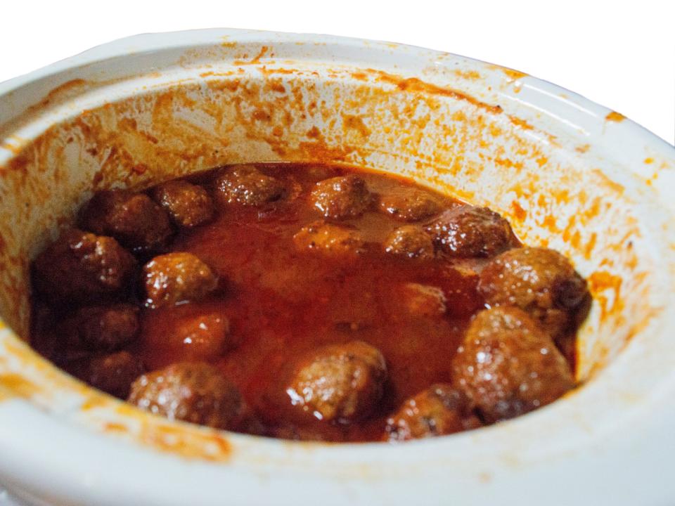 meatballs and red sauce in a white slow cooker