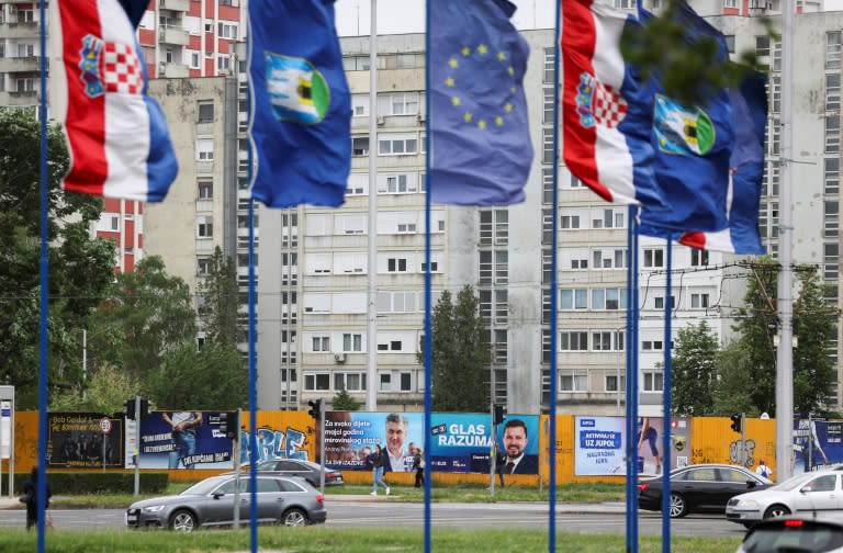 Banderas de Croacia, la ciudad de Zagreb y la Unión Europea ondean frente a afiches electorales, en la capital de Croacia, el 16 de abril de 2024 (Damir SENCAR)