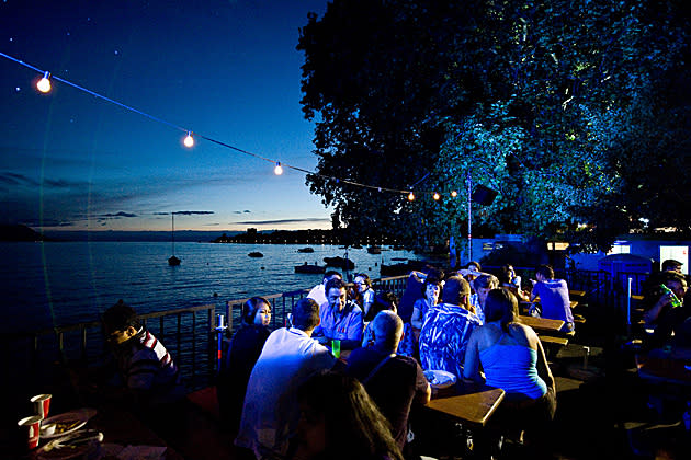 Festival goers take time out from the revelry at Montreux Jazz Festival to relax on the picturesque banks of Lake Geneva.