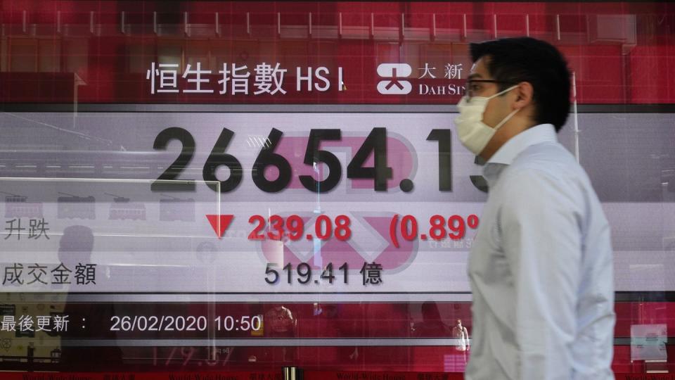Ein Mann geht an einer Anzeigentafel der Hongkonger Börse vorbei. Wegen des Coronavirus rutschen auch Asiatische Aktien ab.