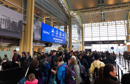 Travelers wait in a security line at Reagan Washington National Airport in Arlington, Virginia, U.S., January 13, 2019. REUTERS/David Shepardson