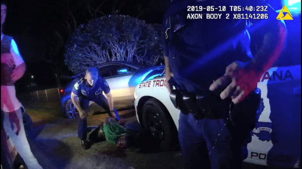 In this image from the body video camera of Louisiana State Police Lt. John Clary, Trooper Kory York stands over Ronald Greene, lying on his stomach, outside of Monroe, La., on May 10, 2019. (Louisiana State Police via AP)