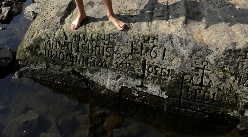 Ein Kind steht auf einem der "Hungersteine", die der niedrige Wasserstand der Elbe im Jahr 2018 offenbart.  - Copyright: REUTERS