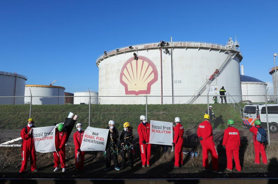 Environmental activist groups including Greenpeace are seen climbing a Shell oil tank to protest against "greenwashing" advertisements in Rotterdam, Netherlands October 4, 2021.