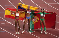 Gold medalist Yulimar Rojas of Venezuela, center, silver medalist Patricia Mamona of Portugal, right, and bronze medalist Ana Peleteiro of Spain, celebrate on the track following the final of the women's triple jump at the 2020 Summer Olympics, Sunday, Aug. 1, 2021, in Tokyo, Japan. (AP Photo/Charlie Riedel)
