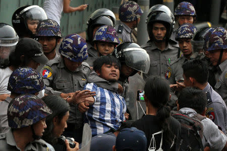 Myanmar police officers detain a student who takes part in a rally demanding peace at the war-torn Kachin State, in Yangon, Myanmar May 12, 2018. REUTERS/Stringer \