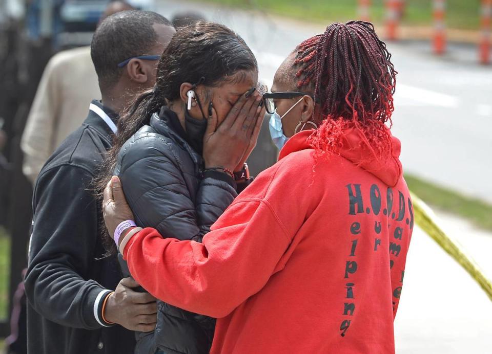 LaTannya Jennings, of New York, center, is comforted by others near the gas station where Charlotte-Mecklenburg Police were investigating the scene of a shooting Tuesday, March 23, 2021. The shooting was at DenÕs Mart at the corner of The Plaza and Parkwood Ave. in Charlotte, NC. LaTannya Jennings of New York said that her brother, Frankie Jennings was the victim of the shooting. Tuesday was Frankie Jennings, 32nd birthday.