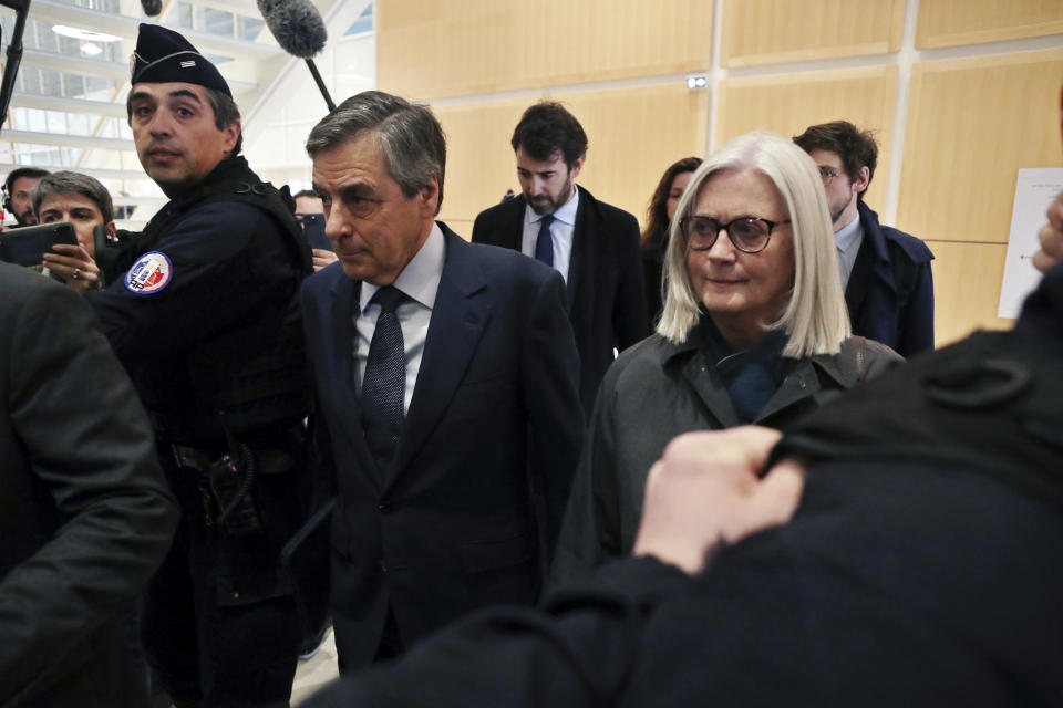 France's former Prime Minister Francois Fillon, left, and his wife Penelope, arrive at the Paris courthouse, in Paris, Wednesday, Feb. 26, 2020. He could have been president of France. Instead, former Prime Minister Francois Fillon is going on trial to face fraud charges after he used public funds to richly pay his wife and children for work they allegedly never performed. (AP Photo/Thibault Camus)