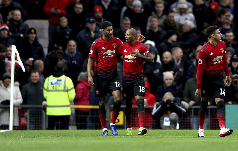 Manchester United's Ashley Young, center right, celebrates scoring his side's first goal of the game with teammate Marcus Rashford during their English Premier League soccer match against Fulham at Old Trafford, Manchester, England, Saturday, Dec. 8, 2018. (Barrington Coombs/PA via AP)