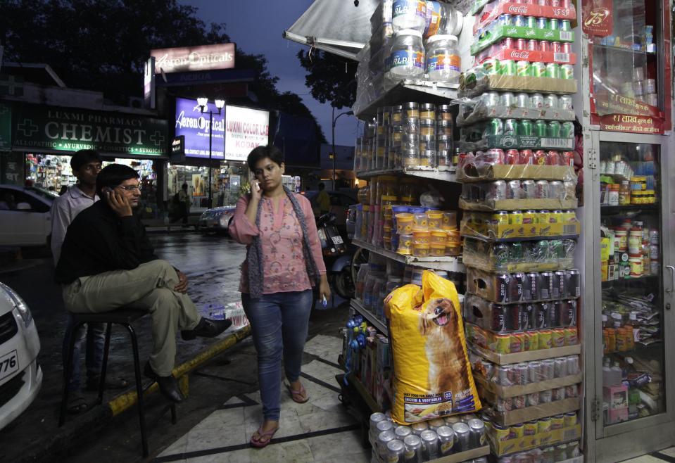 An Indian man speaks on his mobile outside a departmental store, in New Delhi, India, Friday, Sept. 14, 2012. India agreed Friday to open its huge market to foreign retailers such as Wal-Mart as part of a flurry of economic reforms aimed at sparking new growth in the country's sputtering economy. (AP Photo/Manish Swarup)