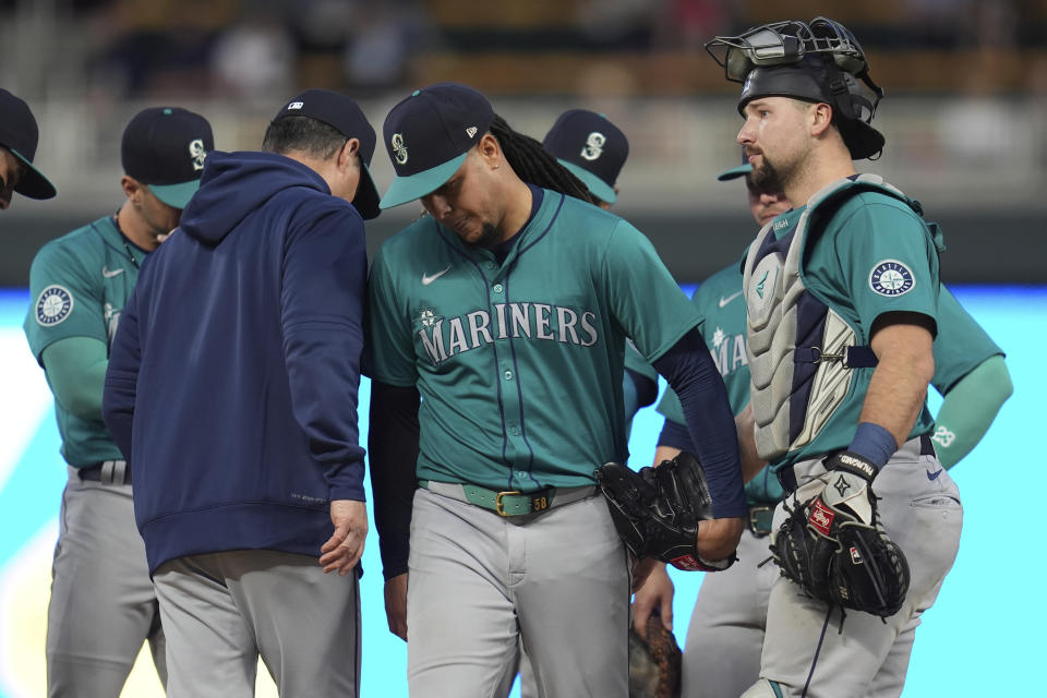 Seattle Mariners starter Luis Castillo, center, leaves the mound during a pitching change in the seventh inning of a baseball game against the Minnesota Twins, Monday, May 6, 2024, in Minneapolis. (AP Photo/Abbie Parr)