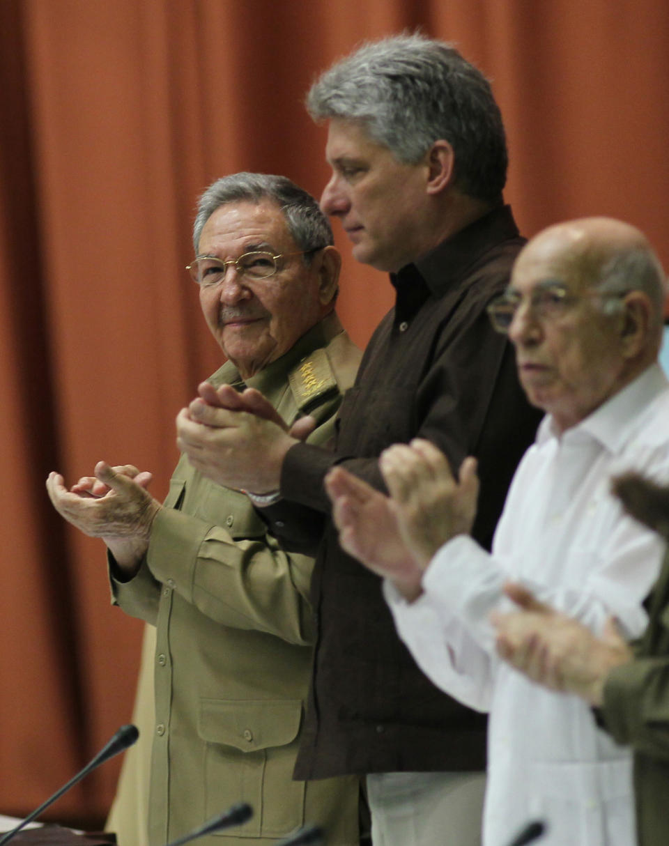 Cuba's President Raul Castro, left, Cuba's Vice President Miguel Diaz-Canel, center, and First Vice-President of the Council of State Jose Ramon Machado Ventura, right, applaud during an extraordinary session at the National Assembly in a vote that overhauls the foreign investment law in Havana, Cuba, Saturday, March. 29, 2014. Cuban lawmakers approved a law Saturday that aims to make it more attractive for foreign investors to do business in and with the country, a measure seen as vital if the island's struggling economy is to improve. (AP Photo/Cubadebate, Ismael Francisco)