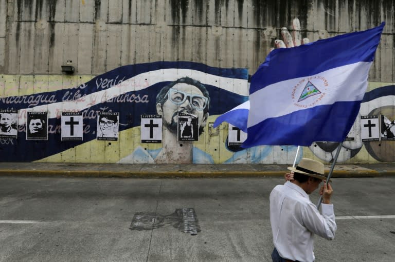 A Nicaraguan opposition demonstrator holds a national flag, as he takes part in a nationwide march called 'United we are a volcano' in Managua on July 12