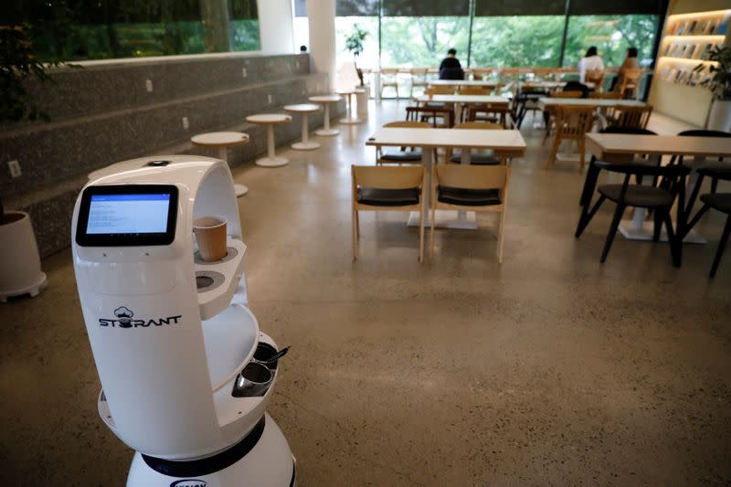 A robot that takes orders, makes coffee and brings the drinks straight to customers at their seats is seen at a cafe in Daejeon