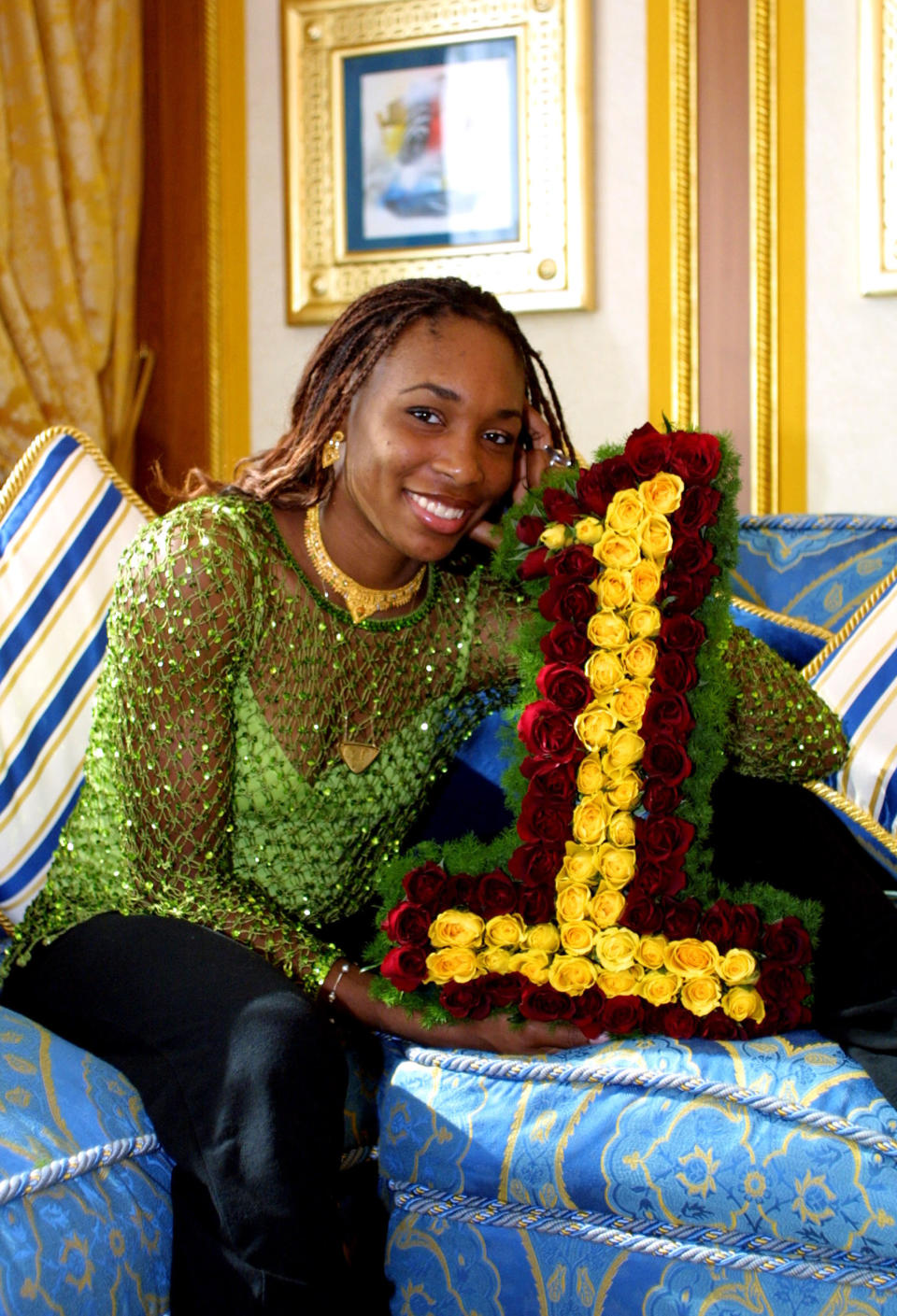 <p>2002 – VENUS WILLIAMS – SPORTS – First African American to hold the #1 rank in tennis and in 2009, she and her sister Serena were the first African-American doubles team to be named year-end world champion by the International Tennis Federation. — American tennis star Venus Williams holds flowers shaped as the “number 1” as she celebrated being ranked the number one female tennis player in the world February 23, 2002 at the 7-star Burj Al Arab Hotel in Dubai, United Arab Emirates. (Ron C. Angle/Getty Images) </p>