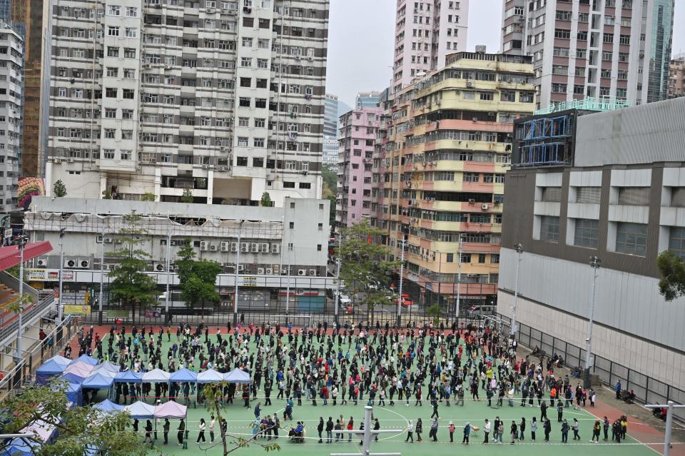 People queue at a mobile specimen collection station for Covid-19 testing in Hong Kongs Mongkok district on February 10, 2022 as authorities scrambled to ramp up testing capacity following a record high number of new infections. (Photo by Peter PARKS / AFP) (Photo by PETER PARKS/AFP via Getty Images)